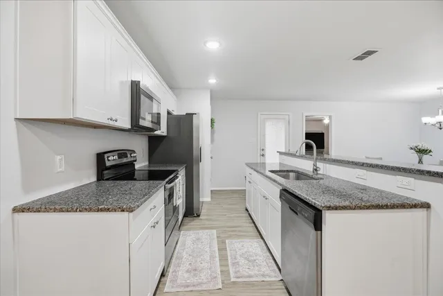 a kitchen with stainless steel appliances granite countertop a sink stove and refrigerator