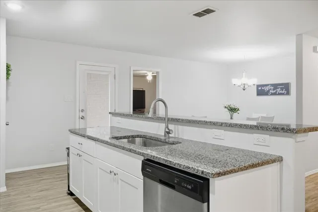 a kitchen with granite countertop a sink and a wooden floor
