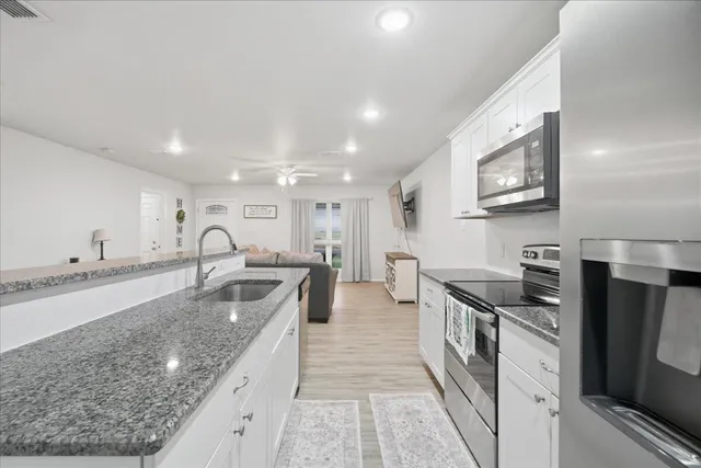 a kitchen with stainless steel appliances granite countertop a sink a stove and a refrigerator