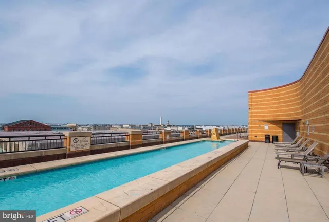 a view of swimming pool with chairs in back yard