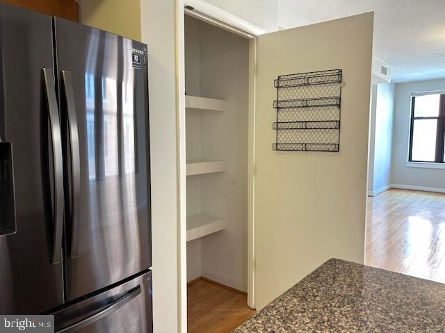 400 Massachusetts Avenue Northwest, Unit 608 Washington, DC 20001 - Photo 7 of 25 a view of a kitchen with wooden floor and a refrigerator
