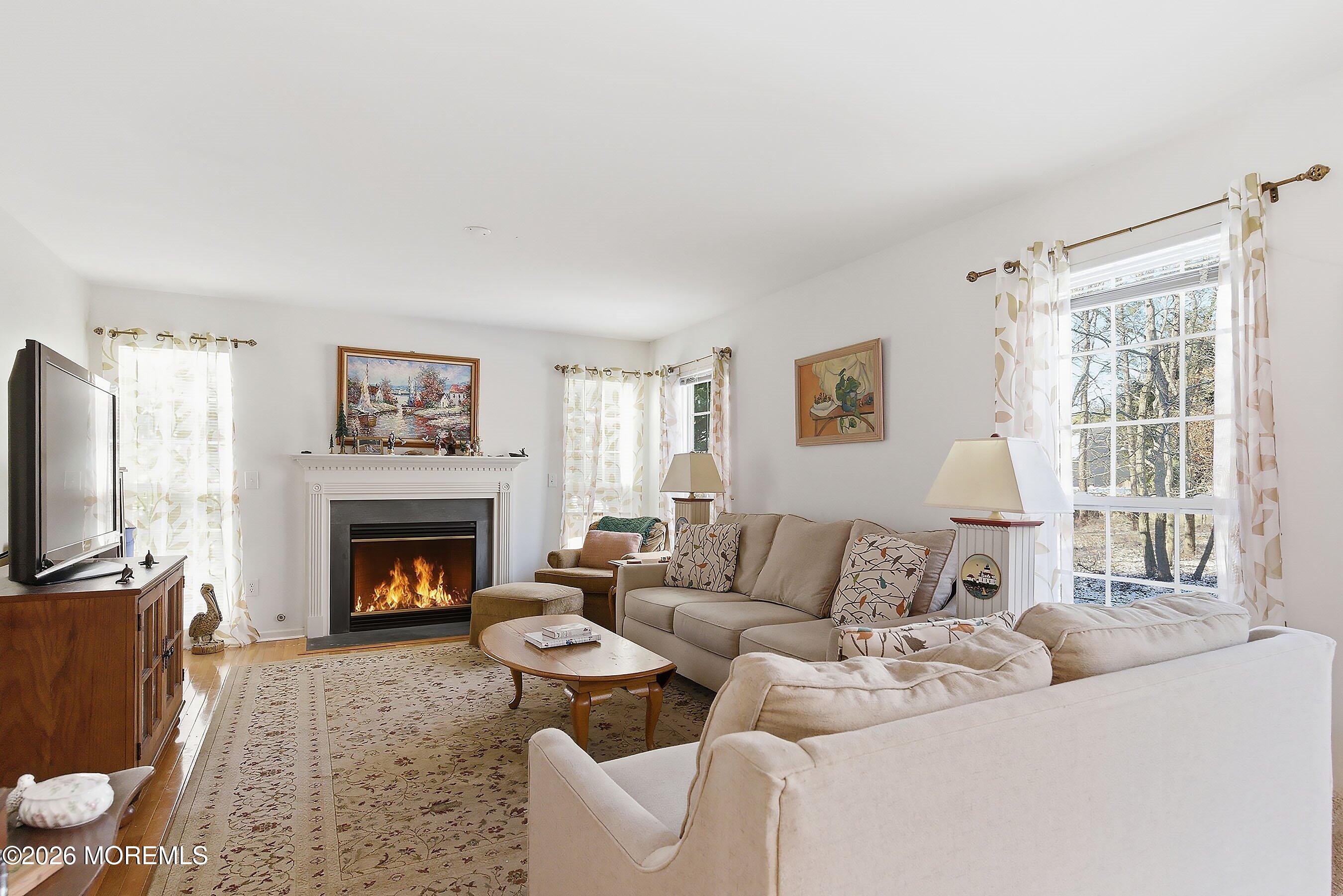 15 Benjamin Court Barnegat, NJ 08005 - Photo 6 of 24 a living room with furniture a flat screen tv and a fireplace