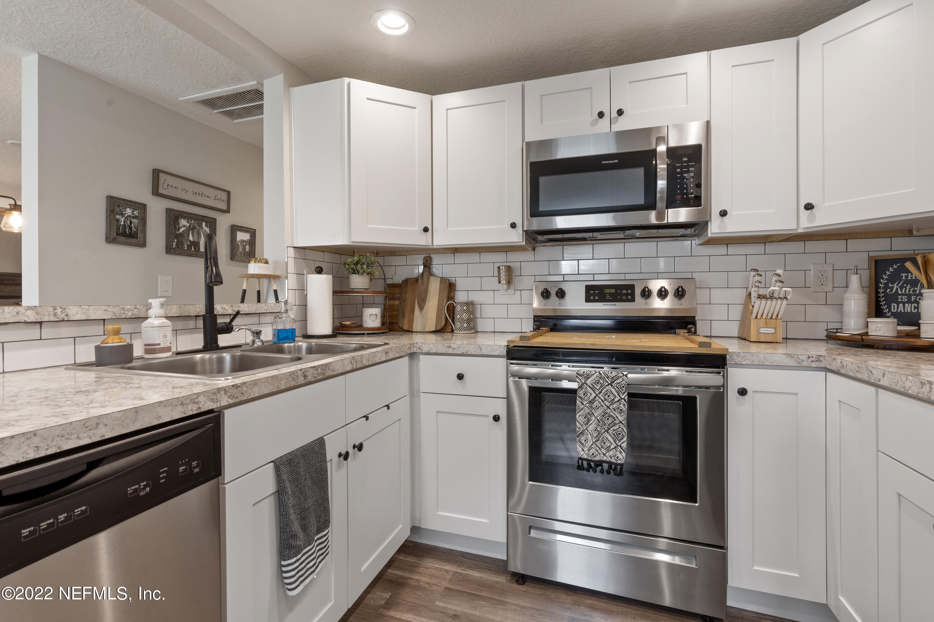 1032 Prince Road St. Augustine, FL 32086 - Photo 17 of 39 a kitchen with granite countertop white cabinets stainless steel appliances and sink
