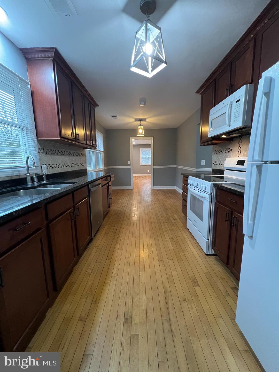 19956 Broad Run Drive Sterling, VA 20165 - Photo 6 of 24 a large kitchen with stainless steel appliances granite countertop wooden floors a stove and a granite counter tops