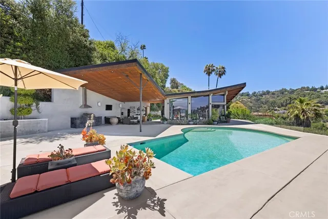 a view of a patio with couches table and chairs under an umbrella