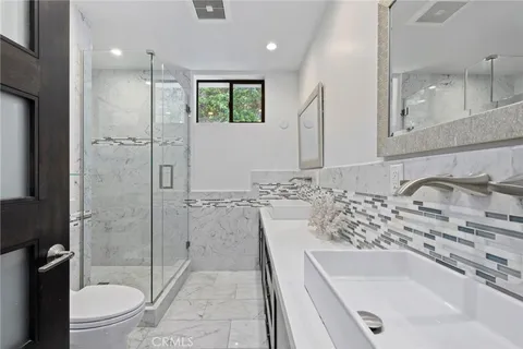 a bathroom with a granite countertop sink a toilet and shower