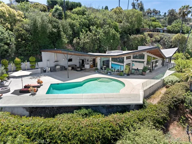 an aerial view of a house with swimming pool and a yard
