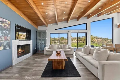 a living room with furniture fireplace and large windows