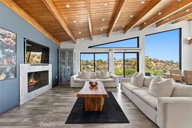 a living room with furniture fireplace and large windows