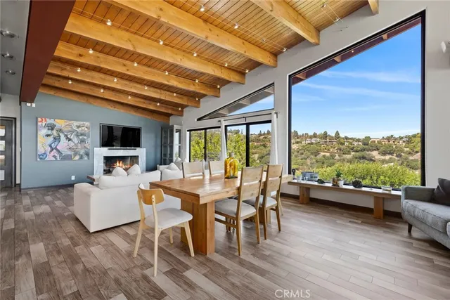 a living room with furniture and a floor to ceiling window next to a large window