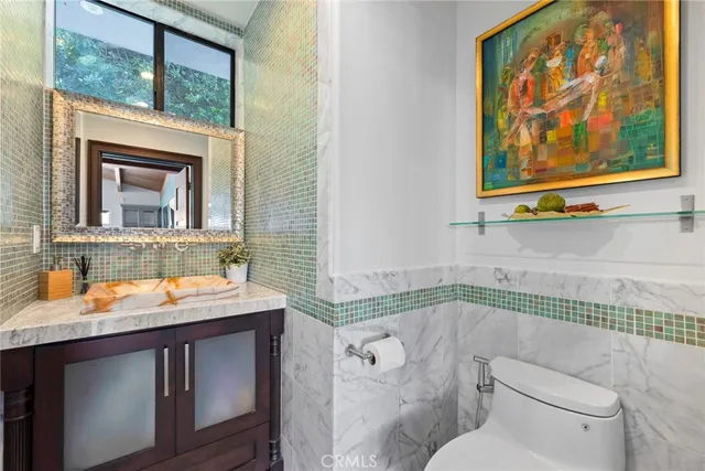 a bathroom with a granite countertop sink mirror vanity and toilet