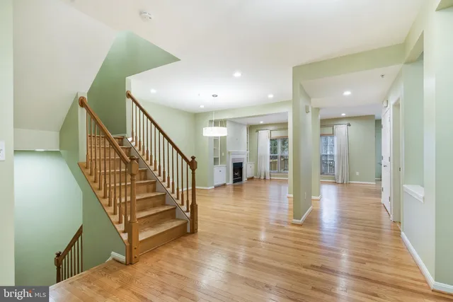a view of a hallway with wooden floor and stairs