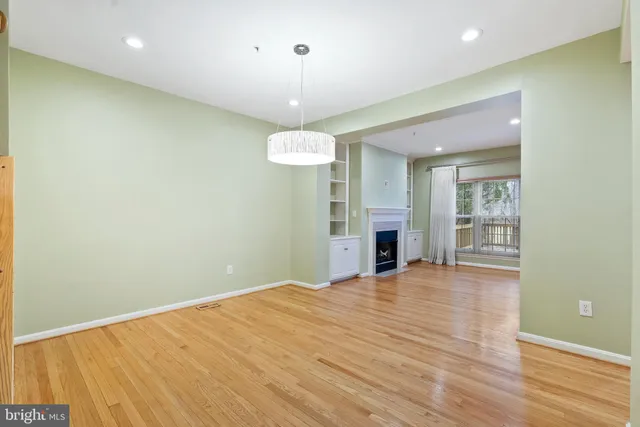 an empty room with wooden floor and large window