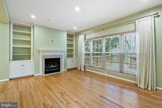 a view of empty room with wooden floor and fireplace