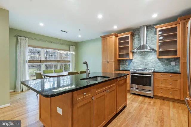 a kitchen with stainless steel appliances granite countertop a stove and cabinets