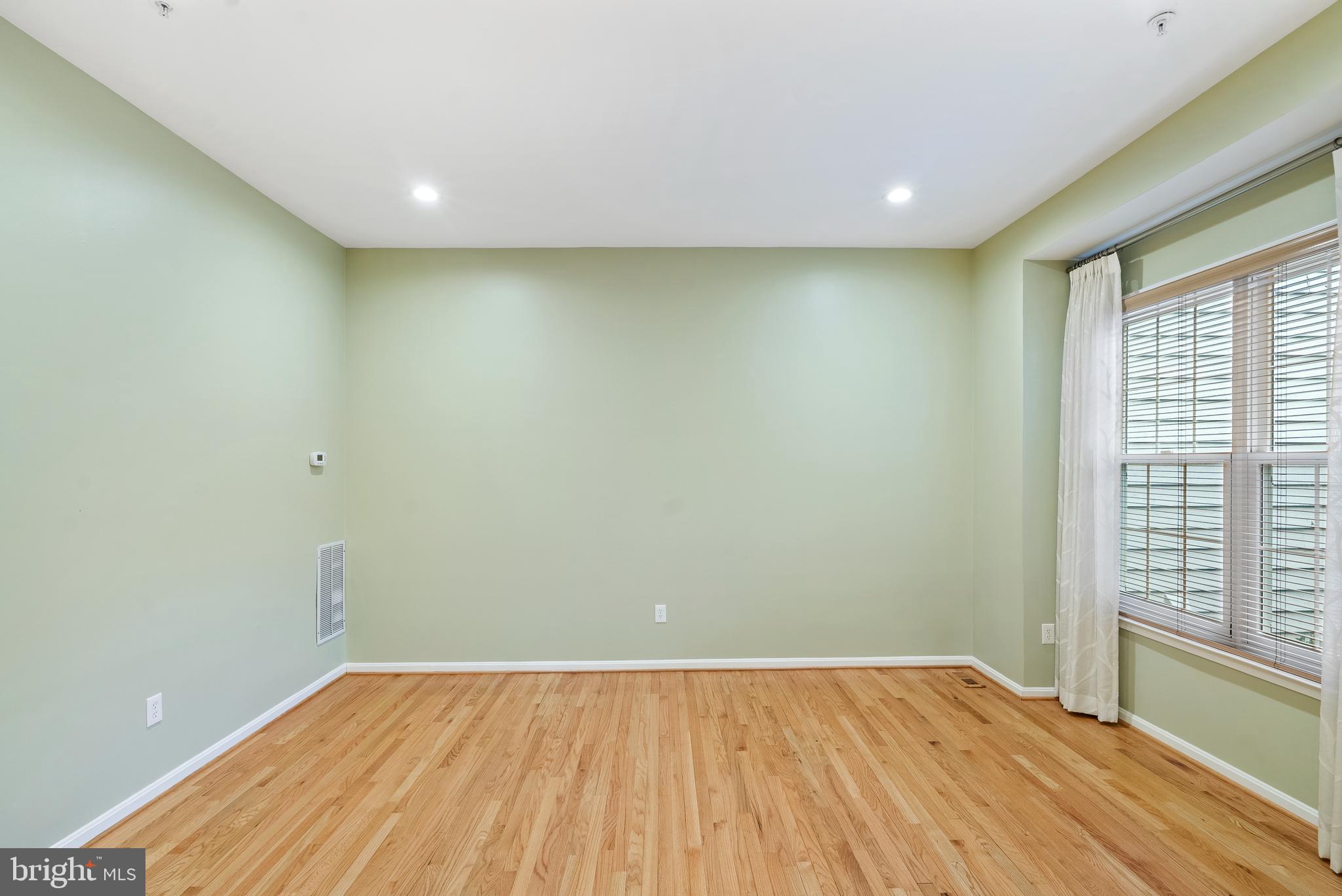 11928 St Francis Way Bowie, MD 20721 - Photo 9 of 48 a view of empty room with wooden floor and fan