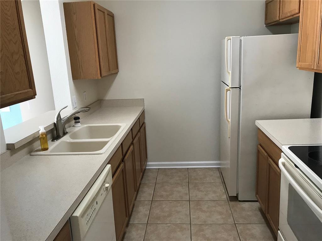 588 Brantley Terrace Way, Unit 303 Altamonte Springs, FL 32714 - Photo 7 of 24 a kitchen with a sink and a refrigerator