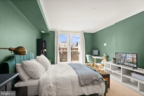 a bedroom with a bed and large windows