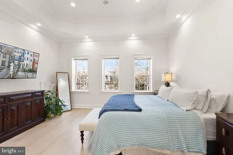 a large bedroom with a bed and wooden floor