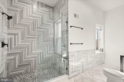 a bathroom with a toilet sink and shower