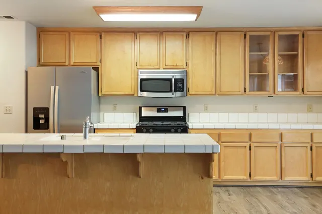a kitchen with stainless steel appliances granite countertop a stove a sink and a microwave