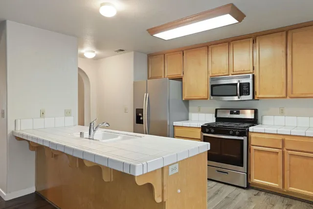 a kitchen with stainless steel appliances a stove sink microwave and cabinets