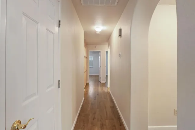 a view of a hallway with wooden floor