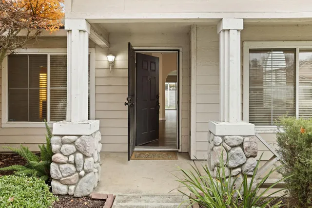 a front view of a house with a potted plant and floor to ceiling window