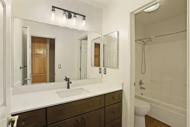 a bathroom with a double vanity sink toilet and shower