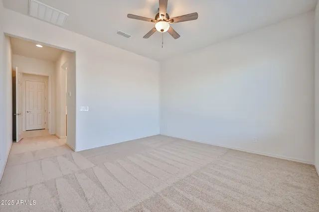 an empty room with fan and a ceiling fan