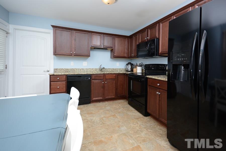 220 Orkney Road Stem, NC 27581 - Photo 6 of 18 a kitchen with stainless steel appliances granite countertop a stove top oven a sink and dishwasher