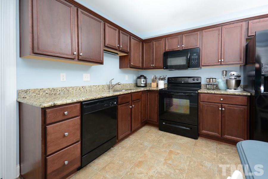 220 Orkney Road Stem, NC 27581 - Photo 7 of 18 a kitchen with stainless steel appliances granite countertop a stove a sink dishwasher and a microwave oven on the wooden cabinets
