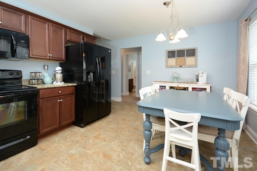 220 Orkney Road Stem, NC 27581 - Photo 8 of 18 a kitchen with a table chairs stove and microwave