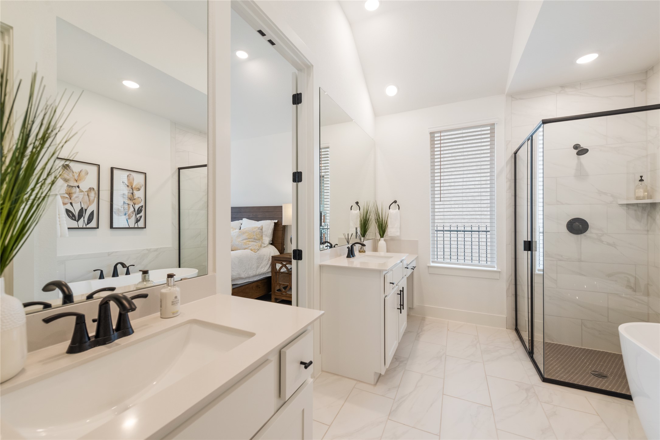 294 Kimble Creek Loop Kyle, TX 78640 - Photo 17 of 40 A bright bathroom with twin vanities and a modern glass shower adjoins a serene bedroom.
