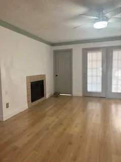 an empty room with windows and fireplace