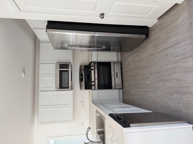 216 Sormonne Loop Kyle, TX 78640 - Photo 6 of 29 a kitchen with stainless steel appliances a refrigerator a sink a stove a microwave and wooden floors