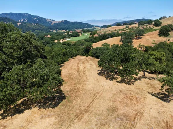 a view of a dry yard with mountains in the background