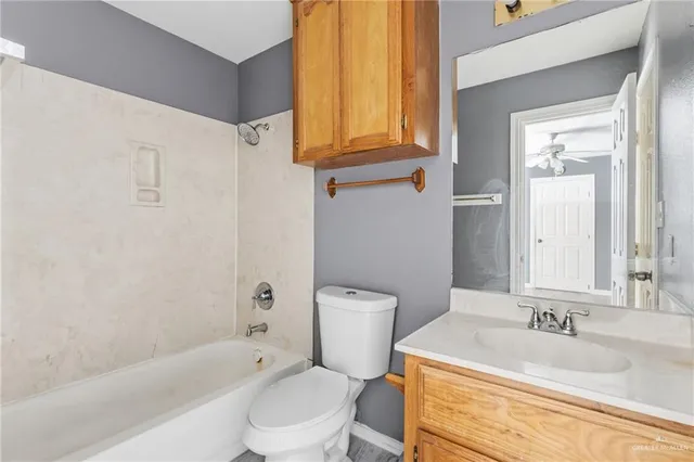 a bathroom with a granite countertop toilet sink and mirror