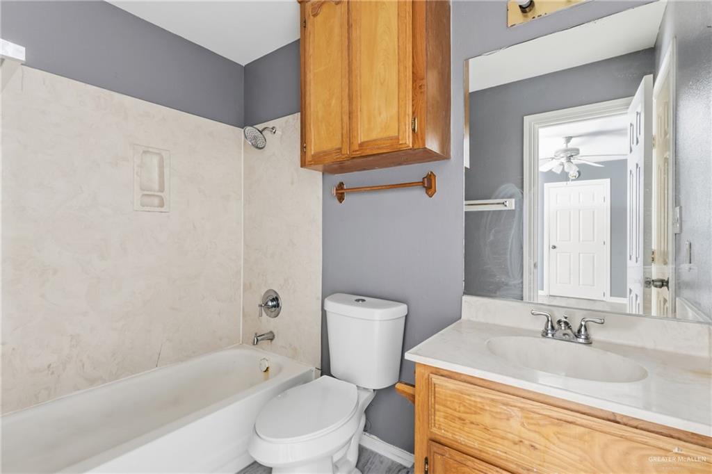 1918 Angus Street, Unit 2 Mission, TX 78572 - Photo 12 of 18 a bathroom with a granite countertop toilet sink and mirror