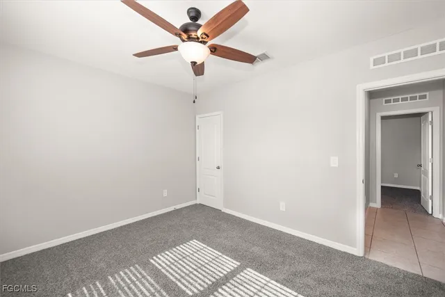 an empty room with fan and a ceiling fan
