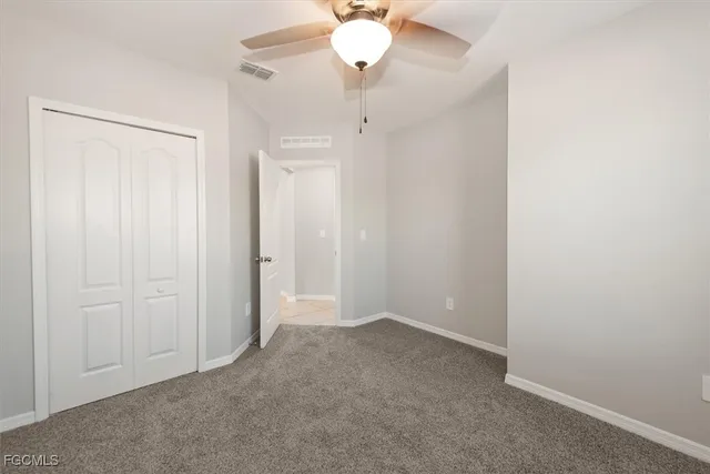 an empty room with chandelier fan