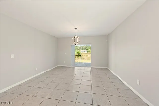 an empty room with windows and chandelier