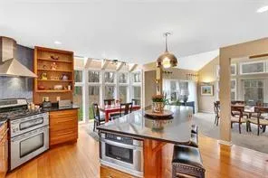 a kitchen with stainless steel appliances a stove and a wooden floor