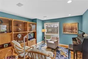 a living room with furniture a flat screen tv and a floor to ceiling window
