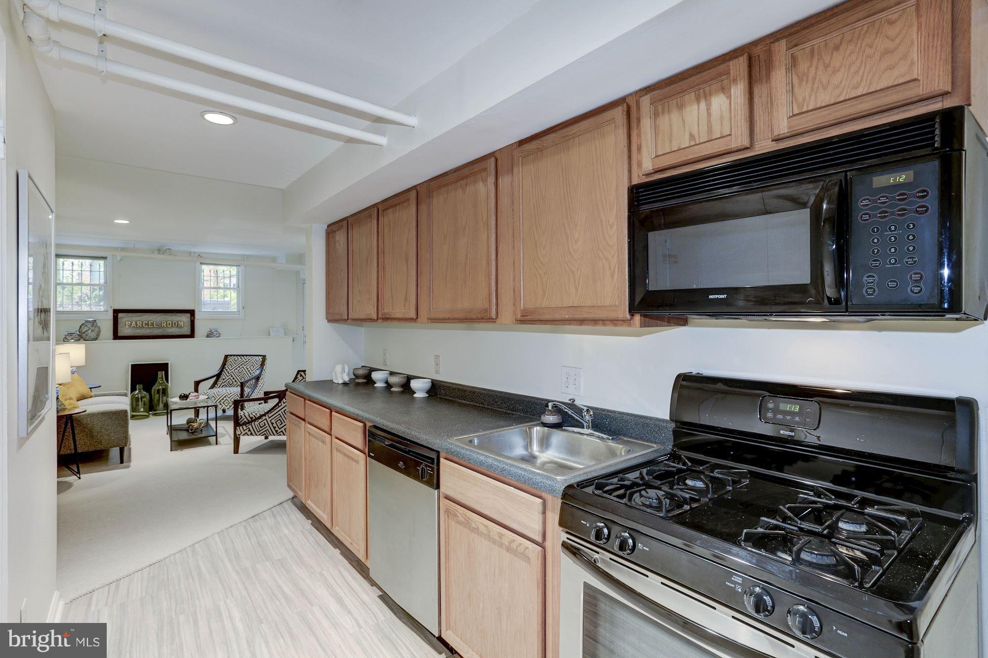 1615 21st Street Northwest Washington, DC 20009 - Photo 24 of 30 a kitchen with stainless steel appliances a stove a sink cabinets and a wooden floor