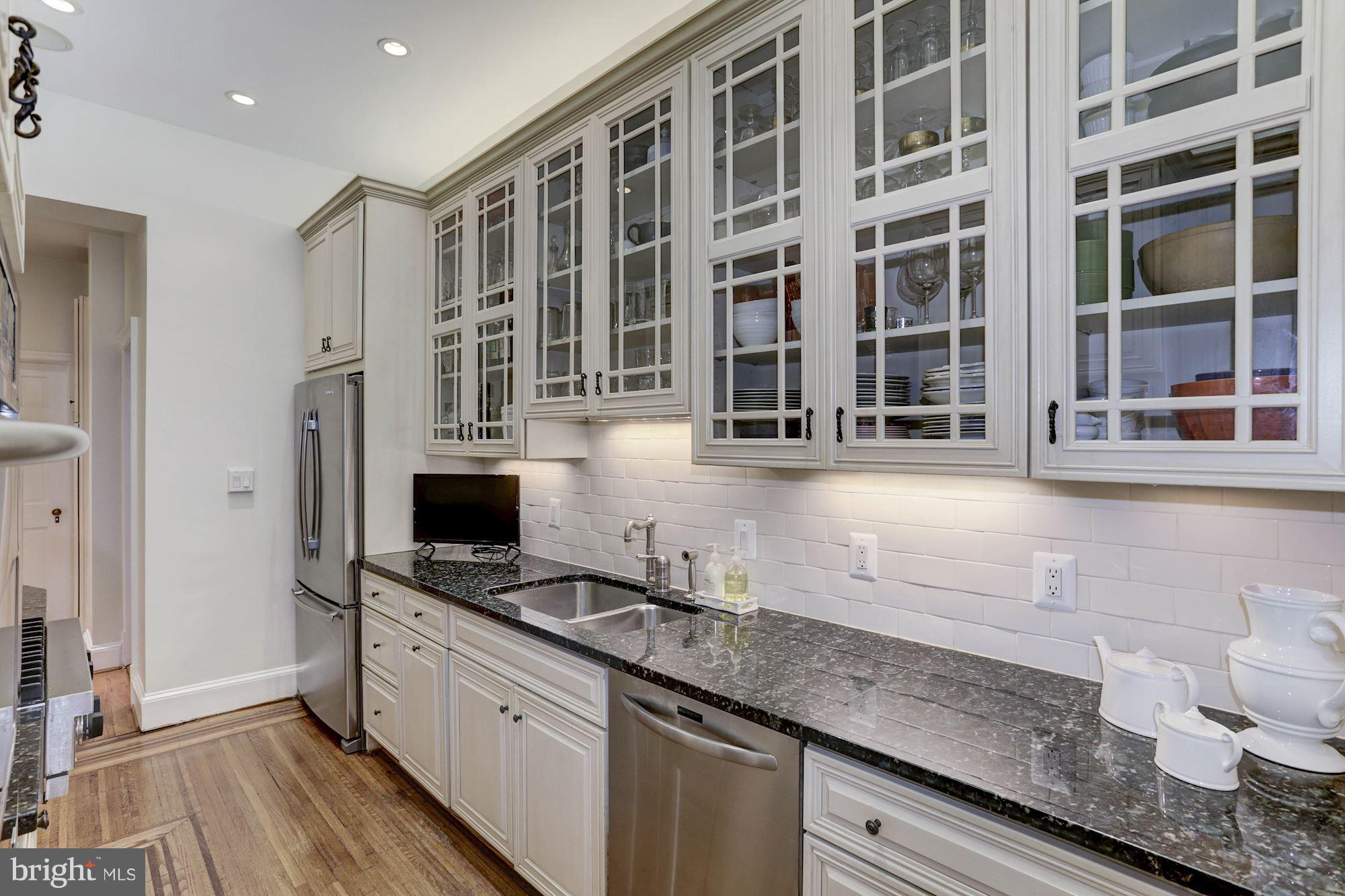1615 21st Street Northwest Washington, DC 20009 - Photo 10 of 30 a kitchen with stainless steel appliances granite countertop a sink stove and cabinets
