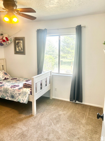570 250 East Parowan, UT 84761 - Photo 18 of 27 Room featuring wall-to-wall carpeting, a window with exterior views, and a ceiling fan with integrated lighting
