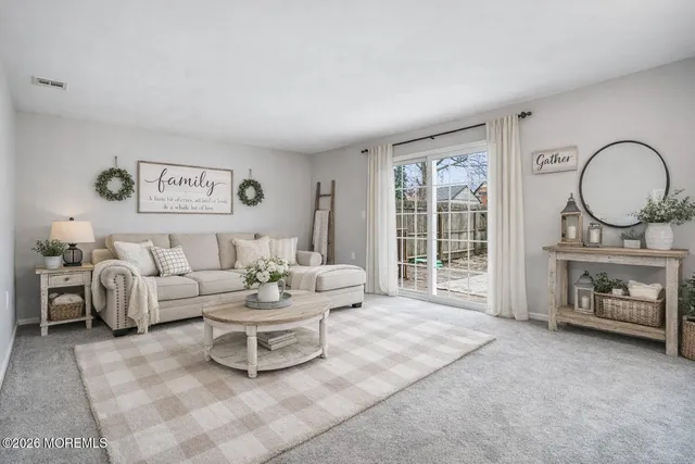 a living room with furniture a fireplace and a large window