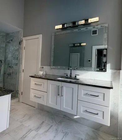 a bathroom with a granite countertop sink double and mirror