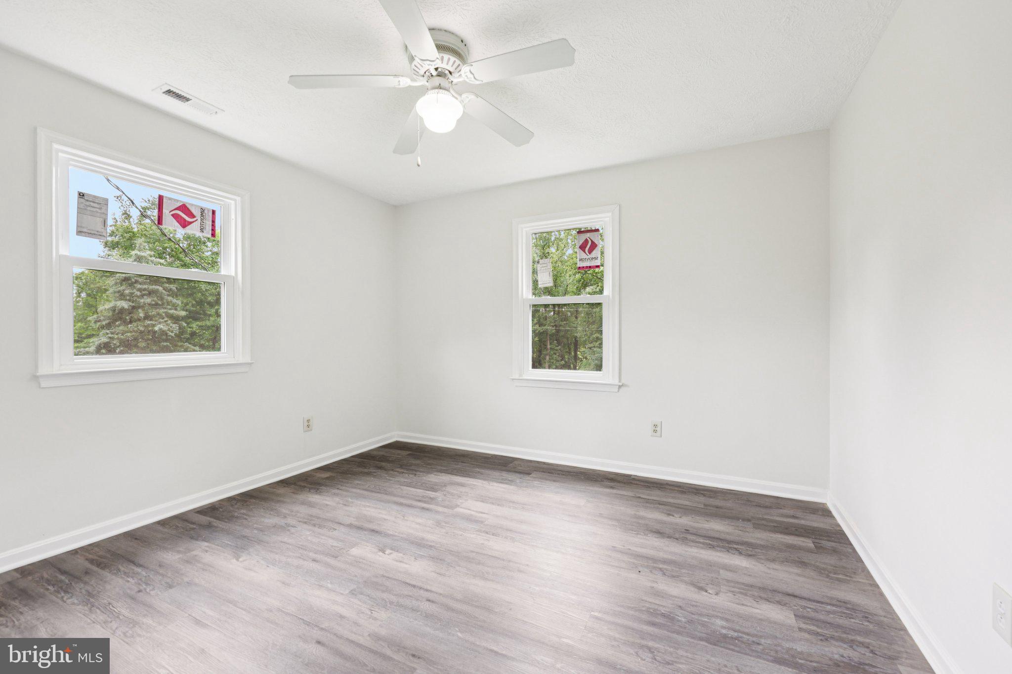 8159 Settle School Road Rixeyville, VA 22737 - Photo 16 of 16 an empty room with wooden floor ceiling fan and windows